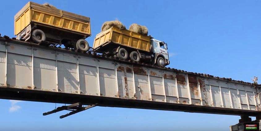 Движение российских грузовых машин по аварийному мосту на реке Витим